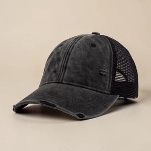 May include: A distressed black baseball cap with a mesh back. The cap has a curved brim and a faded, worn appearance. The mesh back provides ventilation. The cap is a classic accessory.