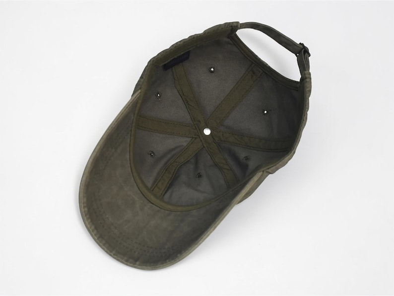 Puede incluir: Gorra de b&eacute;isbol verde oliva con visera curva y correa ajustable. El interior presenta un forro verde oscuro y una corona estructurada. La gorra tiene seis ojales de ventilaci&oacute;n y una correa de tela para ajustar la talla.