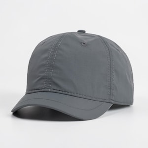 Puede incluir: Una gorra de béisbol de color gris oscuro sólido con una estructura de tela suave y ligera y una visera corta y curva. La gorra presenta un diseño de seis paneles con costuras tonales visibles, un botón en la corona y ojales de ventilación.