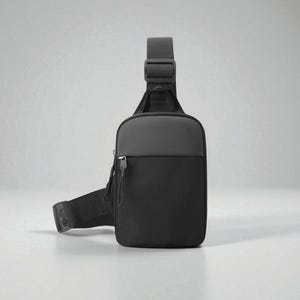Könnte beinhalten: Eine schwarze und graue Sling-Bag mit verstellbarem Schultergurt. Die Tasche hat eine Reißverschluss-Vordertasche und ein gepolstertes Rückenteil. Das Design ist minimalistisch und modern, geeignet für den täglichen Gebrauch.
