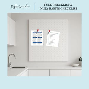 May include: A white pegboard with two sheets of paper pinned to it. One sheet is a full checklist with blue headings and text. The other is a daily habits checklist. The text "Digital Declutter" and "FULL CHECKLIST & DAILY HABITS CHECKLIST" are visible.