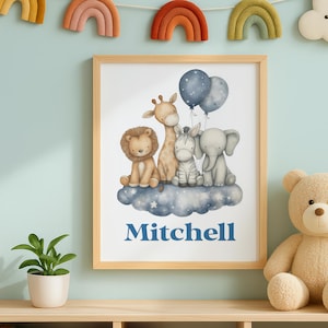 May include: A framed print featuring a watercolor illustration of a lion, giraffe, zebra, and elephant on a cloud, with blue balloons. The name "Mitchell" is printed in blue below the animals. The frame is light brown.