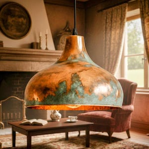 May include: A large, copper-colored pendant light fixture with a wide, bell-shaped shade. The shade has a distressed finish with areas of green and brown, and a warm, inviting glow emanates from the exposed bulb. The fixture hangs from a black cord.