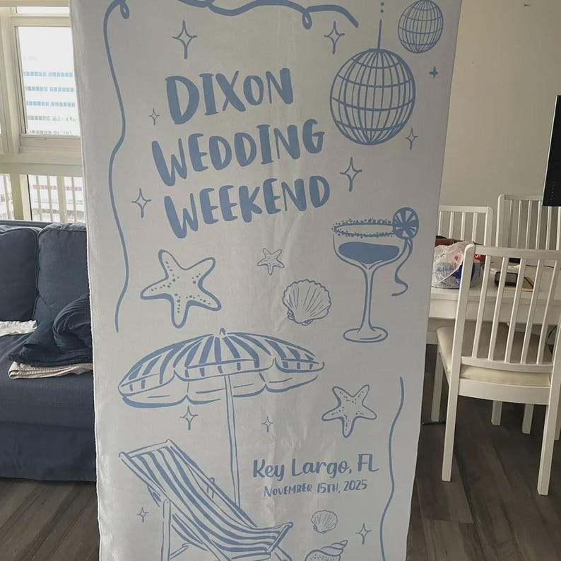 Pode incluir: Uma faixa branca com ilustra&ccedil;&otilde;es e texto em azul claro. A faixa diz "Dixon Wedding Weekend" com gr&aacute;ficos tem&aacute;ticos de praia, como um coquetel, uma bola de discoteca e uma cadeira de praia. A localiza&ccedil;&atilde;o e a data, "Key Largo, FL November 15th, 2025" tamb&eacute;m est&atilde;o inclu&iacute;das.