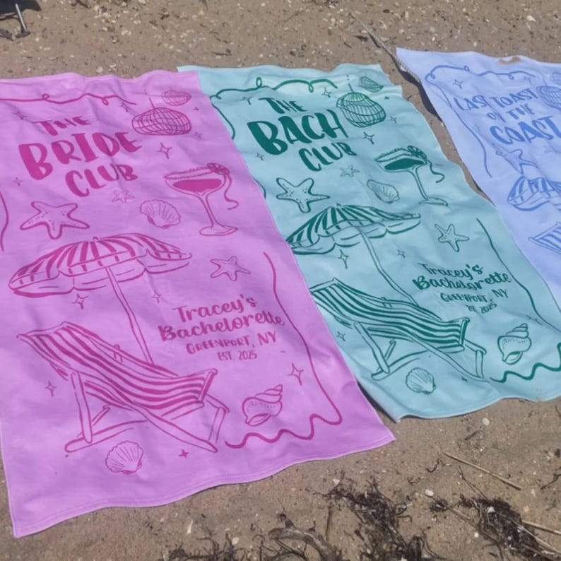 Pode incluir: Tr&ecirc;s toalhas de praia em rosa, verde-azulado e roxo claro, cada uma com texto e ilustra&ccedil;&otilde;es &uacute;nicas. A toalha rosa diz "The Bride Club" e "Tracey's Bachelorette". A toalha verde-azulado diz "The Bach Club". A toalha roxa clara diz "Last Toast of the Coast".