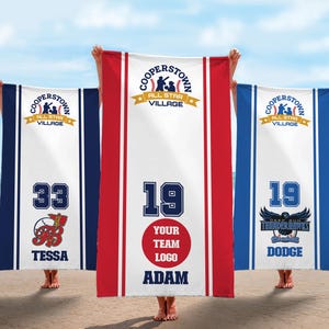 May include: Three personalized baseball-themed beach towels. Each towel features the text "Cooperstown All Star Village" at the top. One towel has the number 33 and the name "Tessa", another has the number 19 and the name "Adam", and the third has the number 19 and the name "Dodge".