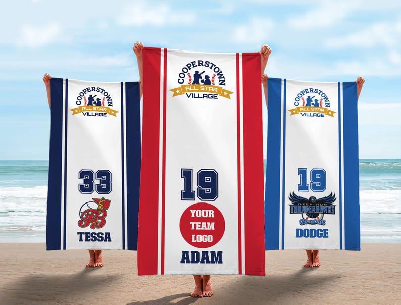 May include: Three baseball-themed beach towels, each with the text "Cooperstown All Star Village". One towel displays the number 33 and the name "Tessa", another has the number 19 and the name "Adam", and the third has the number 19 and the name "Dodge".