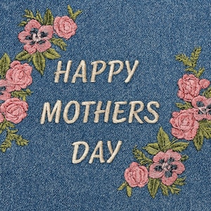 Könnte beinhalten: Gesticktes Denim-Design mit dem Text "HAPPY MOTHERS DAY" in cremefarbenem Garn. Rosafarbene Rosen und andere Blumen mit grünen Blättern sind um den Text herum gestickt und bilden einen floralen Rahmen.