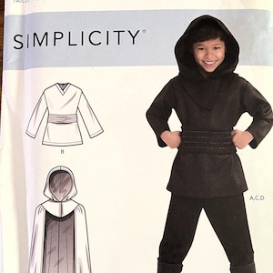 Puede incluir: Patrón de disfraz Simplicity S9162 para tallas 3-8. La imagen muestra a un niño con una túnica con capucha y pantalones negros, con ilustraciones de los componentes del disfraz. El patrón incluye una capa y una túnica con cinturón.