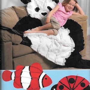 May include: Simplicity fleece throw pattern featuring a panda bear design with black and white fleece. The pattern also includes designs for a red and white clownfish and a red and black ladybug. The text "fleece throws" is visible.