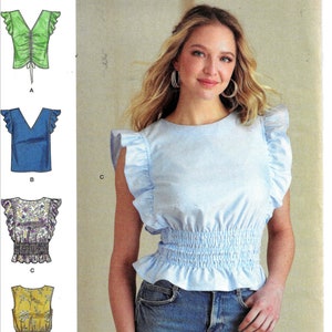 May include: A sewing pattern for a women's top with a ruffled neckline and sleeves. The pattern includes four different styles: a green top with a drawstring, a blue top with a V-neck, a floral print top with a gathered waist, and a yellow top with a gathered waist. The pattern is labeled "Simplicity" and "R11535".