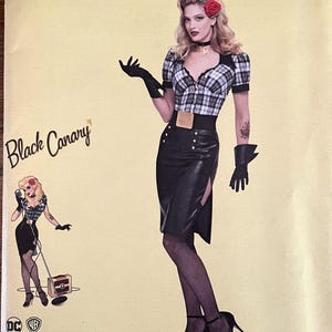 Puede incluir: Un patrón de costura Simplicity con un diseño de DC Comics Bombshells. El patrón incluye un disfraz de Black Canary. La ilustración muestra a una mujer con una blusa a cuadros, falda negra y guantes. El patrón está impreso en EE. UU.