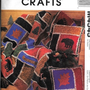 Könnte beinhalten: Ein Nähmuster für eine Patchwork-Decke mit Waldmotiv. Die Decke zeigt verschiedene Tier- und Naturmotive, darunter Bären, Bäume und Blätter. Das Muster stammt von McCall's Crafts und trägt den Titel "Une Pochette Un Sobre".