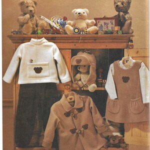 May include: A sewing pattern for children's clothing, featuring a white sweater with a bear pocket, brown trousers, a brown coat with toggle closures, and a brown pinafore dress with a bear applique. The pattern is from Vogue for Me and is for all sizes.