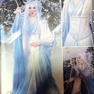 May include: A Simplicity sewing pattern for a white dress with a blue overlay and a corset bodice. The pattern is for a fantasy or fairy costume. The pattern number is S8971.