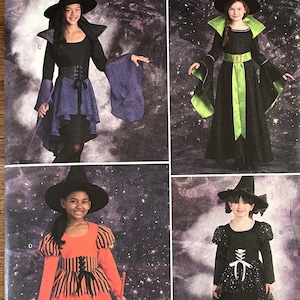 Peut inclure: Patron de couture Simplicity pour costumes de sorcières pour enfants. L'image présente quatre modèles de costumes différents, chacun avec un chapeau de sorcière noir et une variété de styles de robes aux couleurs noir, orange et violet. Les costumes ont des détails uniques.