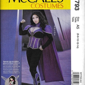 May include: A sewing pattern for a purple and black costume with a cape. The pattern is for sizes 6-8-10-12-14 and includes separate cup size patterns for A/B, C, and D.