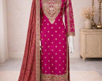 Può includere: Un completo salwar kameez magenta con ricami dorati. L'outfit include una tunica a maniche lunghe, pantaloni a gamba larga e una sciarpa fantasia abbinata. Il manichino mostra l'abito tradizionale indiano e pakistano.
