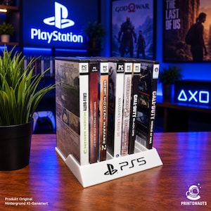 Könnte beinhalten: Ein weißer Kunststoff-Aufbewahrungsständer mit dem PlayStation 5-Logo auf der Vorderseite, der eine Sammlung von sieben Videospielhüllen enthält. Der Ständer dient zur Organisation von Spiel-Discs und zeigt Titel wie Call of Duty und Assassin's Creed.