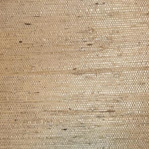 May include: Close-up of a woven textile with a natural, beige color. The texture is rough and irregular, with visible fibers and a grid-like pattern. The material appears to be made of natural fibers.