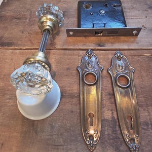Set di ferramenta per porte vintage decorata con pomelli in vetro tagliato e serratura a incasso.