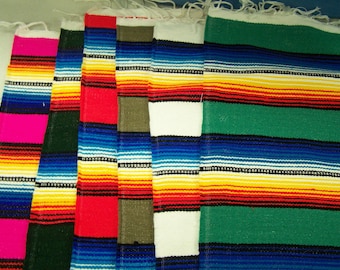May include: A set of six colorful striped woven blankets. The blankets are in various colors, including pink, green, red, blue, white, and yellow. The blankets are made of a soft, woven fabric and have a fringed edge.