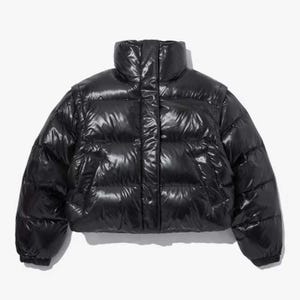 May include: A glossy black puffer jacket with a high collar. The jacket has a shiny, quilted appearance and a cropped length. The sleeves have elastic cuffs. The jacket is designed to provide warmth and protection from the elements.