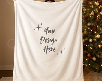 May include: A large, off-white blanket with the text "Your Design Here" in a script font. The blanket is held up in front of a Christmas tree with gold and red ornaments. The blanket has a soft, plush appearance.