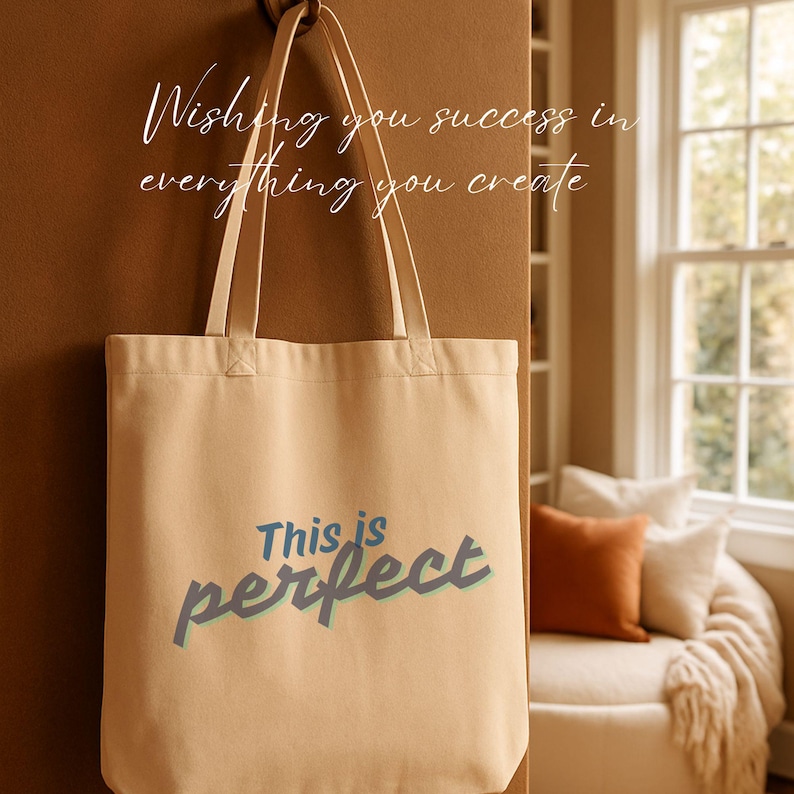Może przedstawiać: Beżowa pł&oacute;cienna torba z napisem "This is perfect" w niebieskich i turkusowych literach. Torba wisi na haczyku. Nad torbą napis "Wishing you success in everything you create" jest napisany białym skryptem.