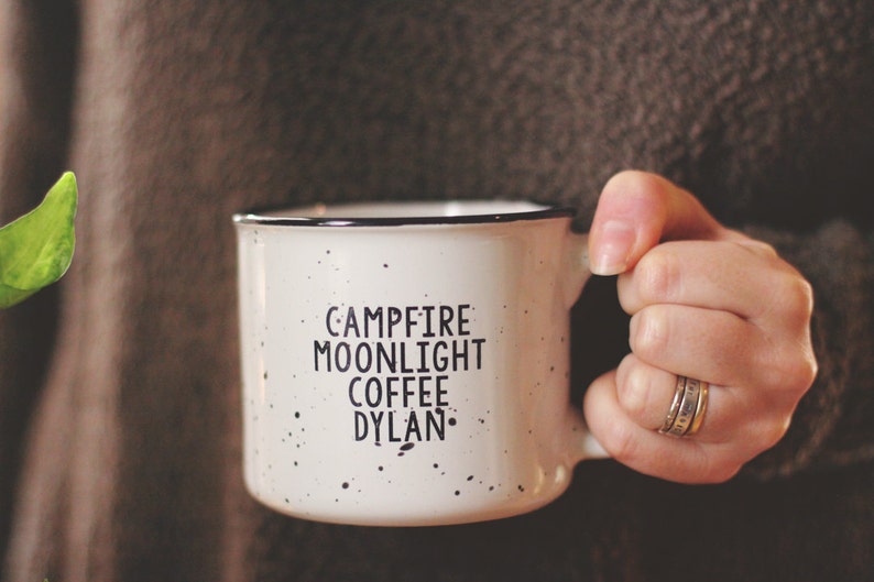 Ceramic coffee mug that says Campfire Moonlight Coffee Dylan.  White speckled 13oz campfire style mug. inspired by our love of Bob Dylan