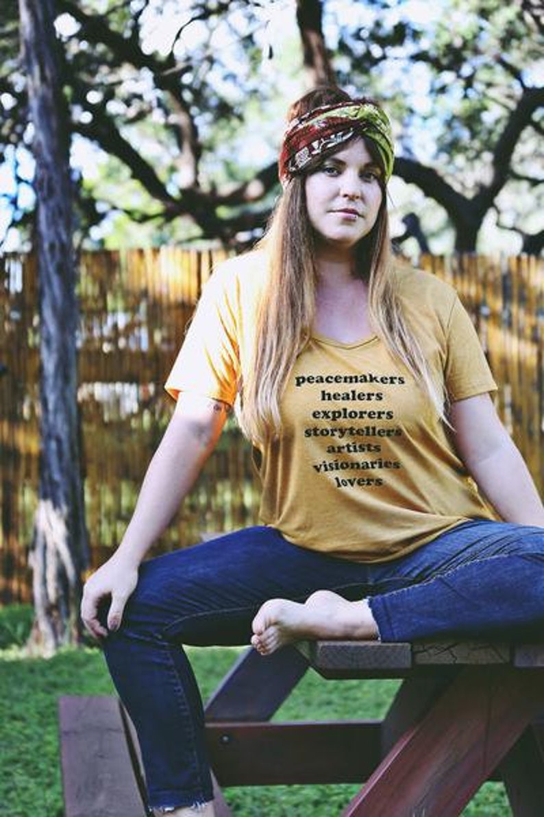 Flowy, soft mustard colored tshirt says "Peacemaker Healers Explorers Artists Visonaries Lovers" 
Printed with black ink. Perfect for any boho woman.