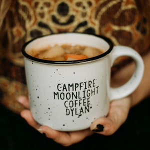 Ceramic coffee mug that says Campfire Moonlight Coffee Dylan.  White speckled 13oz campfire style mug. inspired by our love of Bob Dylan