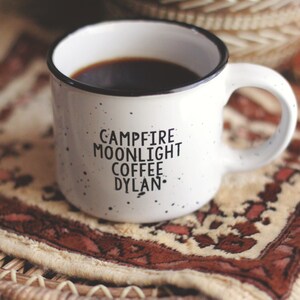 Ceramic coffee mug that says Campfire Moonlight Coffee Dylan.  White speckled 13oz campfire style mug. inspired by our love of Bob Dylan