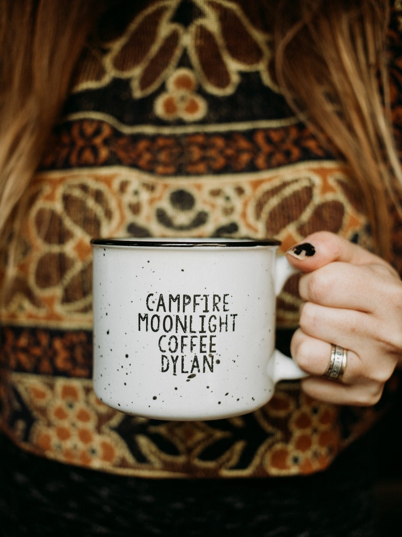 Ceramic coffee mug that says Campfire Moonlight Coffee Dylan.  White speckled 13oz campfire style mug. inspired by our love of Bob Dylan