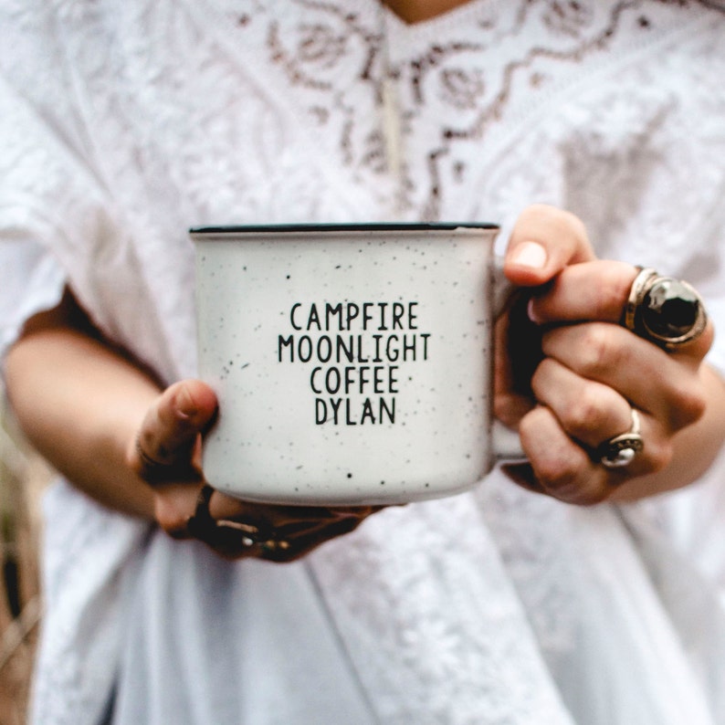 Ceramic coffee mug that says Campfire Moonlight Coffee Dylan.  White speckled 13oz campfire style mug. inspired by our love of Bob Dylan