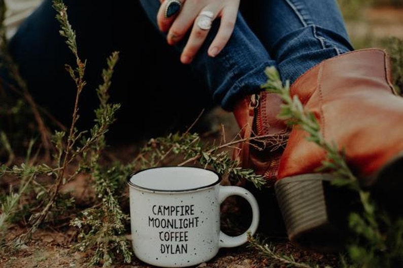 Ceramic coffee mug that says Campfire Moonlight Coffee Dylan.  White speckled 13oz campfire style mug. inspired by our love of Bob Dylan