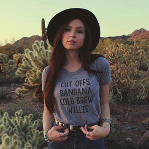 Grey womens and unisex top. Says Cut Offs Bandana Cold Brew Willie.  Inspired by our love of Willie Nelson.