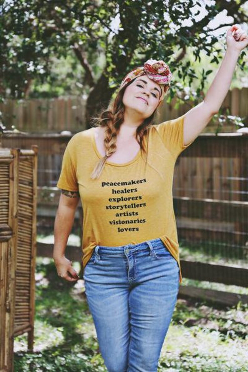 Flowy, soft mustard colored tshirt says "Peacemaker Healers Explorers Artists Visonaries Lovers" 
Printed with black ink. Perfect for any boho woman.