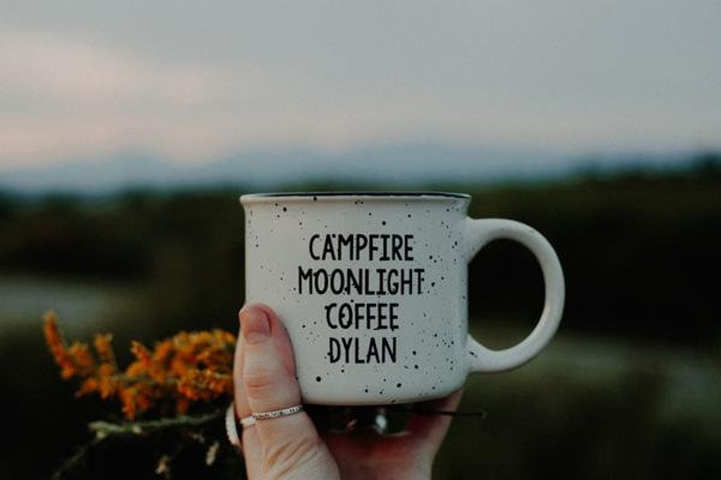 Ceramic coffee mug that says Campfire Moonlight Coffee Dylan.  White speckled 13oz campfire style mug. inspired by our love of Bob Dylan