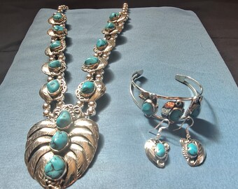 Conjunto de joias com colar, brincos e pulseiras em prata turquesa com pingente em formato de flor de abóbora.