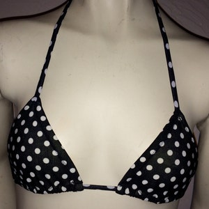 May include: Black and white polka dot bikini top with adjustable straps.