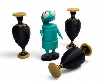 May include: A turquoise character figurine with large white eyes stands in the center, surrounded by three black vases with yellow circular bases and rims. The vases feature gold-colored decorative patterns near the neck.