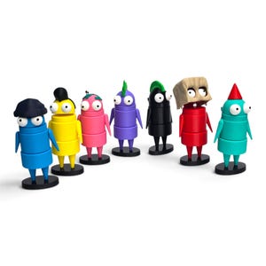 Może przedstawiać: Zestaw siedmiu małych, kolorowych, cylindrycznych figurek stojących na czarnych okrągłych podstawkach. Każda postać ma dwoje dużych białych oczu, cienkie ramiona i charakterystyczne nakrycia głowy, w tym czapki, włosy i maskę z papierowej torby w kolorze niebieskim, żółtym, różowym, fioletowym, czarnym, czerwonym i turkusowym.