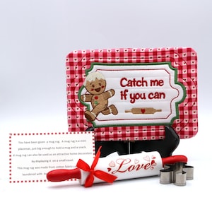 May include: A festive mug rug featuring a gingerbread man and the text "Catch me if you can". The rug has a red and white gingham pattern. Includes a rolling pin with "Love" printed on it and small cookie cutters.