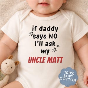 May include: A cream-colored baby bodysuit featuring black text that reads, if daddy says NO i'll ask my, followed by the name UNCLE MATT in red capital letters. The design includes small star graphics and a blue badge stating 100% SOFT COTTON.