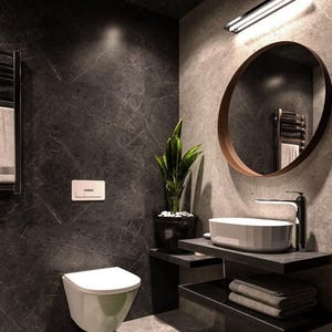 Op de afbeelding: Moderne badkamer met donkergrijze muren en vloer met marmerlook. Voorzien van een wit toilet, een ronde spiegel met een houten frame, een witte wastafel en een zwart rek met handdoeken. Een potplant voegt een vleugje groen toe.
