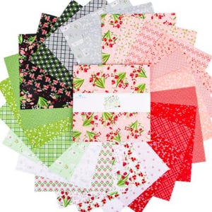 May include: A collection of fabric squares arranged in a circular pattern. The fabrics feature various floral and geometric designs in shades of green, pink, red, and white. A central stack of squares is wrapped with a label that reads "Fiori".