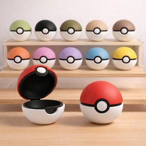 Può includere: Una tazza di ceramica bianca con un manico nero e la scritta "But First, Coffee" in nero, con un carattere a mano. La tazza è su una superficie bianca.