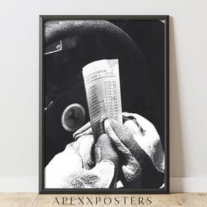 May include: Monochrome framed print showing a race car driver's gloved hands holding a race results sheet. The print includes the text "APEXXPOSTERS". The image is a black and white photograph of a racing scene.