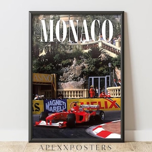 May include: Framed poster featuring a red Formula 1 race car speeding around a track in Monaco. The word "MONACO" is displayed in large white letters at the top. The poster includes the text "APEXXPOSTERS" at the bottom.